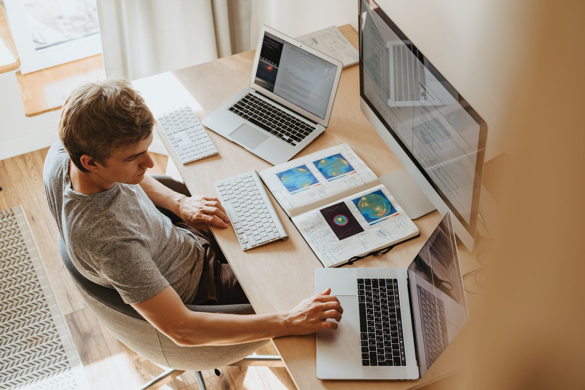 Man studying business in front of 3 monitors
