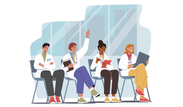 four young physicians sitting in chairs in a classroom