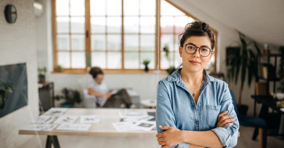 Young female graphic designer posing at her new office setup