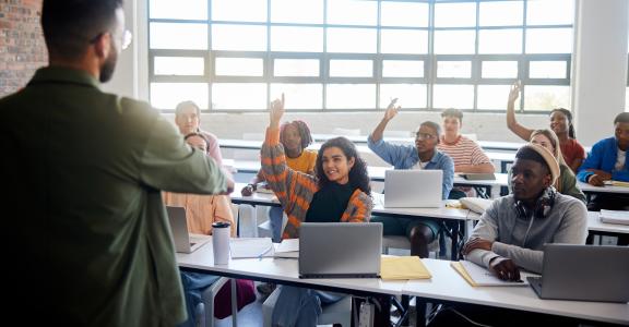 classroom of students raising their hand