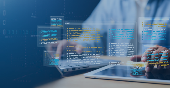 Person typing on laptop and iPad with programming illustration overlay