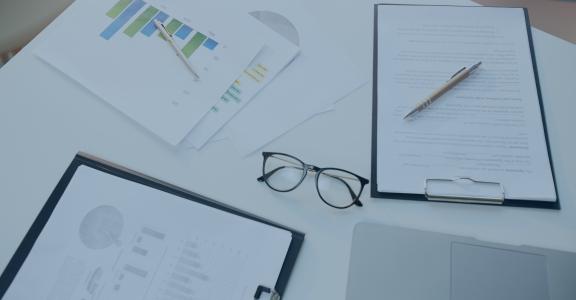 Business documents on desk with pair of glasses