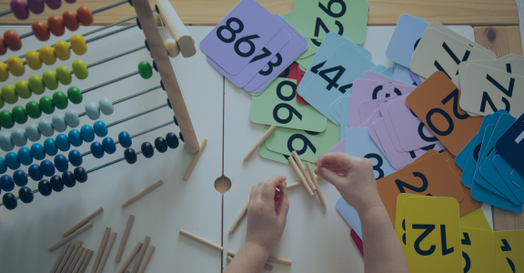Pair of hands playing with math related toys