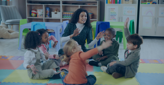 Teacher singing with group of kids in a circle