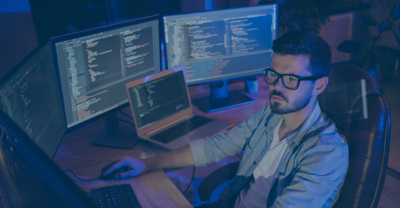 Man coding and writing script in a dark room