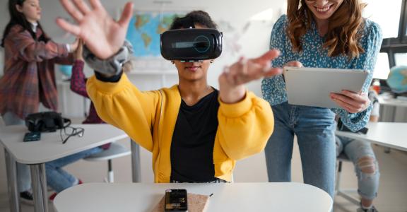 Teenage students wearing virtual reality goggles at school in a computer science class