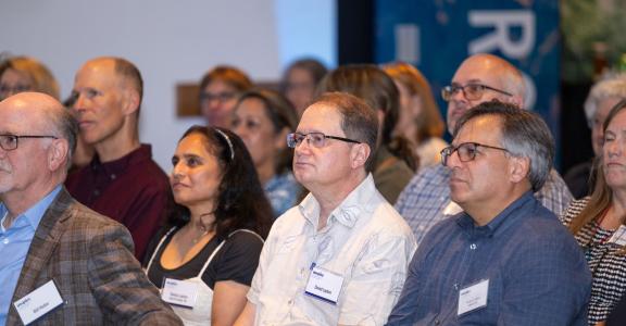 Older people sitting in event room listening to a presentation
