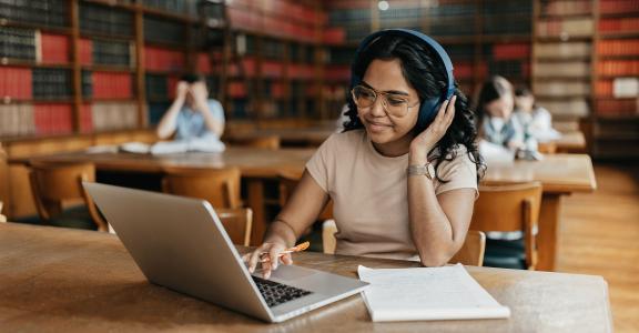 Female Indian student working on the laptop in the university library