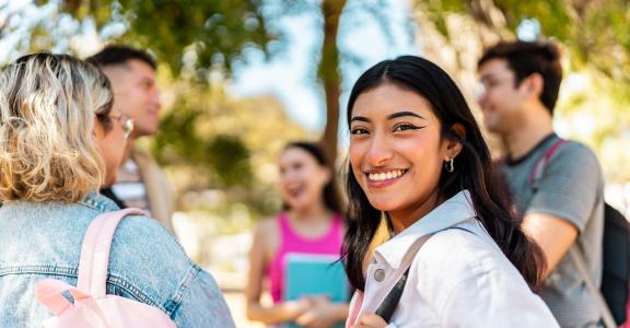 Portrait of a young woman with friends outdoors