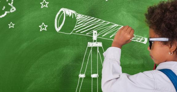 Preschool child looking through telescope