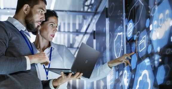 Business man and woman consulting at a wall of digital image