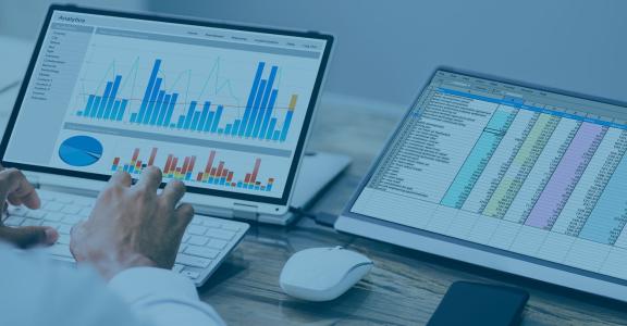 man typing on tablet and looking at graphs