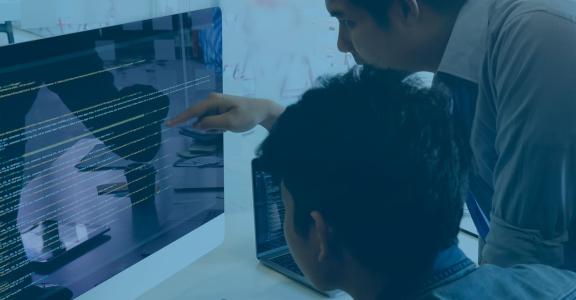 Two men looking at computer code