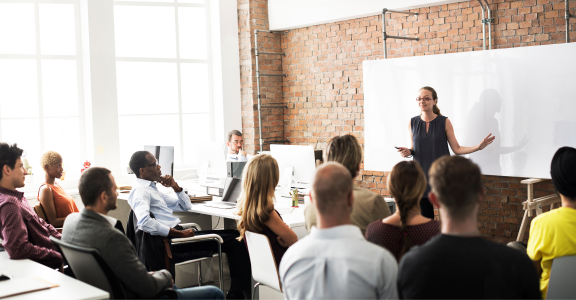 Instructor teaching in front of business people