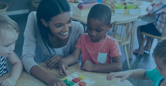 teacher showing toddlers colorful shapes