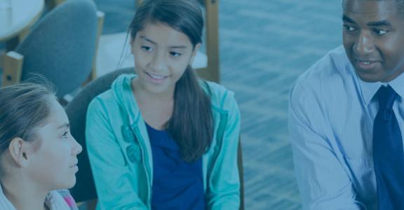 male teacher talking to two young girls