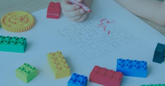 Hands drawing shapes from colorful lego blocks