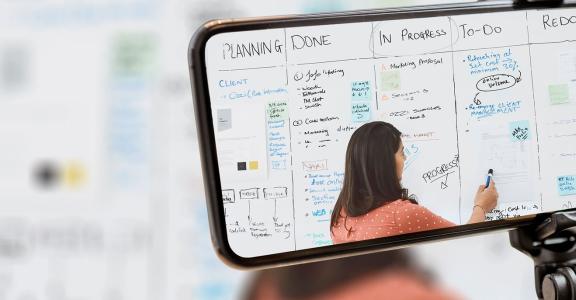 Instructor teaching on a white board being streamed to a sma