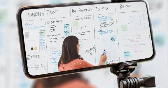 Instructor teaching on a white board being streamed to a sma