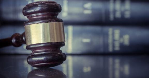Judicial gavel on table with a background of law books