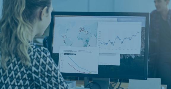 Woman looking at larger computer monitor