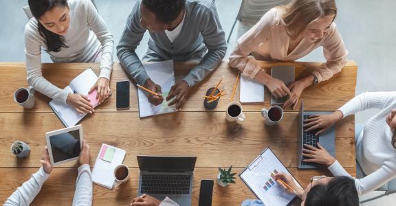 View from above of students talking around a conference table