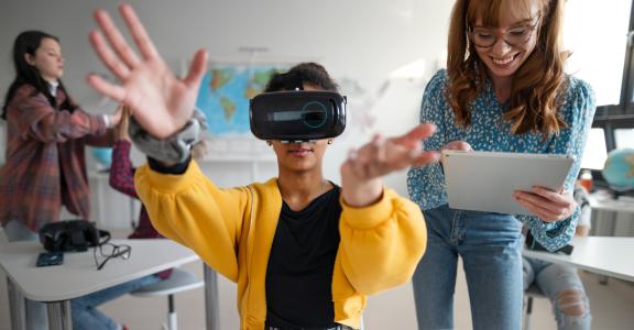 Teenage students wearing virtual reality goggles at school in a computer science class