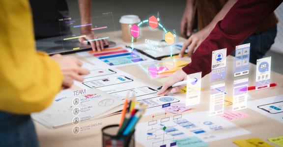 Close up ux developer and ui designer use augmented reality brainstorming about mobile app interface wireframe design on desk at modern office.