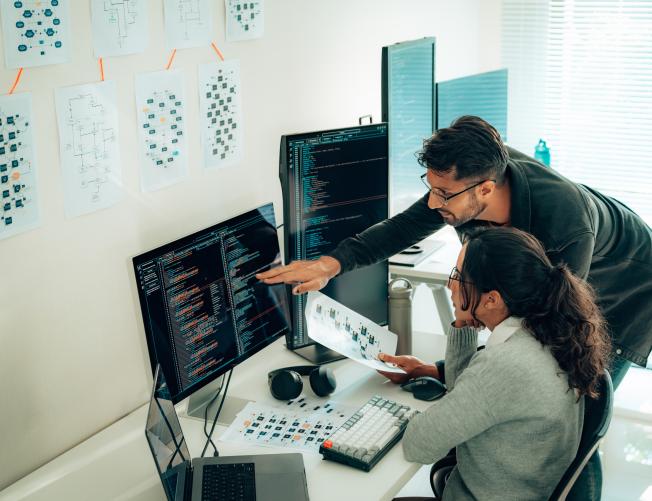 senior engineer helping colleague with code