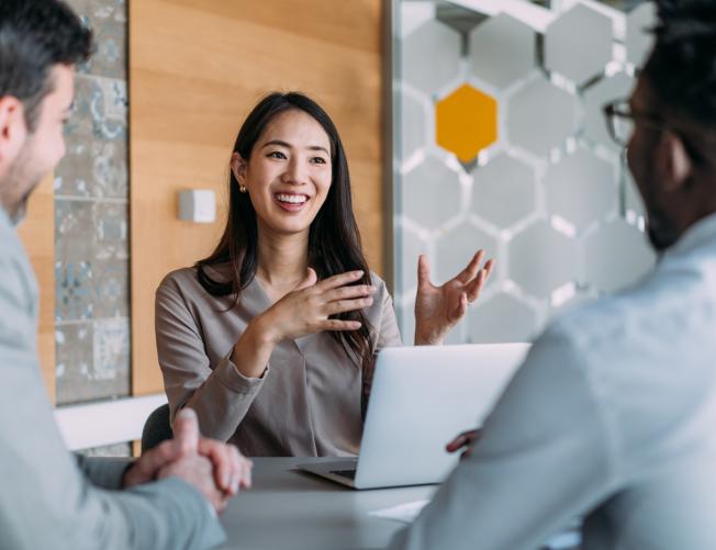 Woman having a meeting and discussing with two colleagues