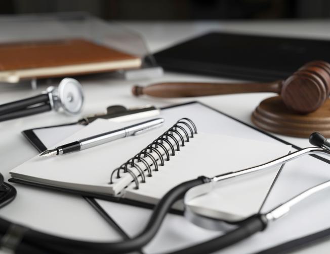 stacked notebook and clipboard with stethoscope and gavel
