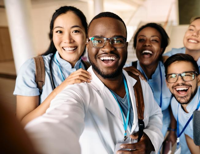 Multi-ethnic group of happy medical students having fun while taking selfie