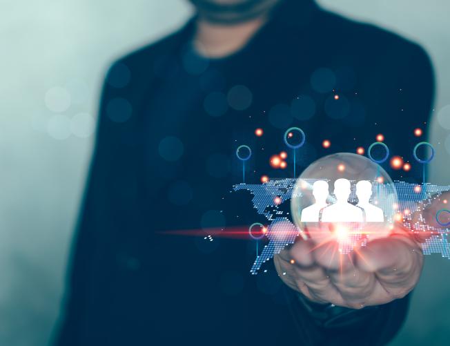 Man in suit holding glass globe with a network structure world map and business digital network technology