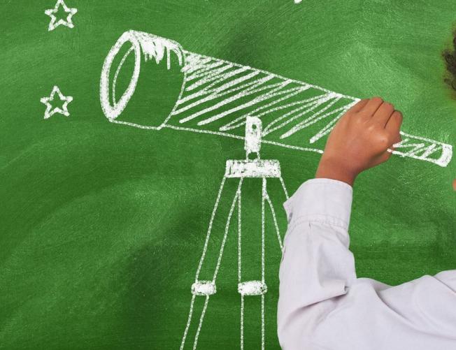 Preschool child looking through telescope