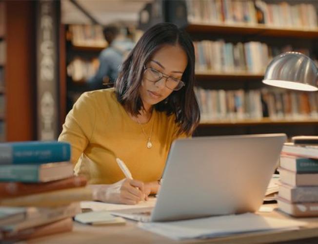 Woman studying at a laptop in a library