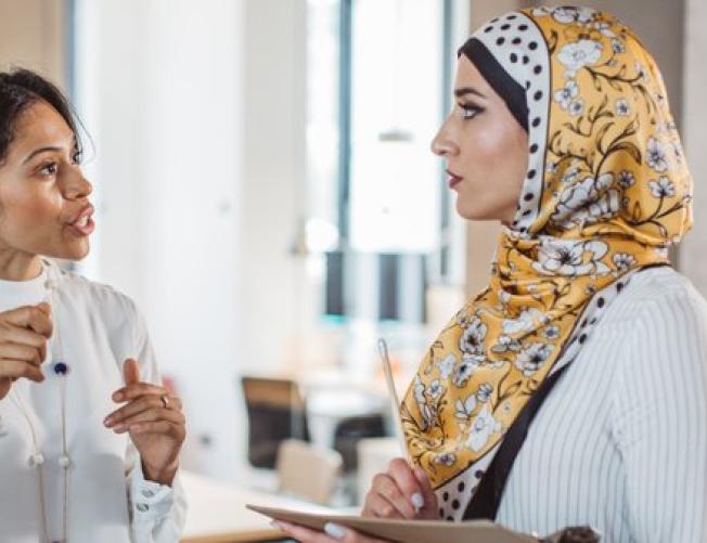 two woman talking in a classroom