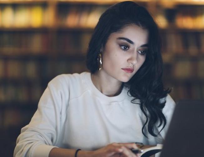 woman in library looking at laptop