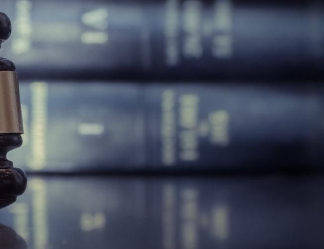 Judicial gavel on table with a background of law books