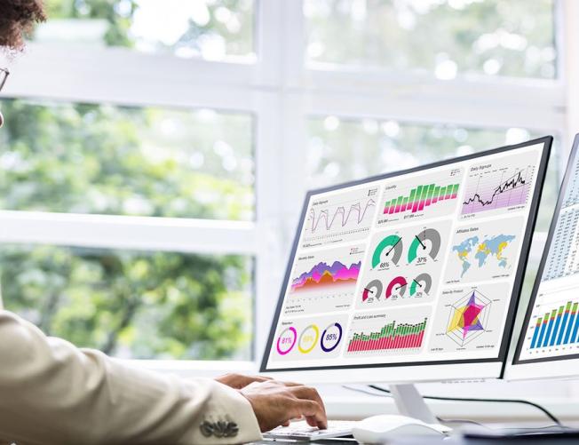 Business man at a desk looking at charts and data graphs on 