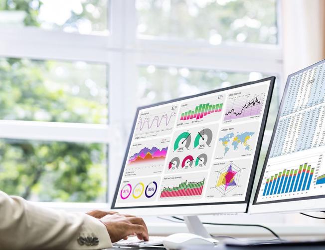 Business man at a desk looking at charts and data graphs on 