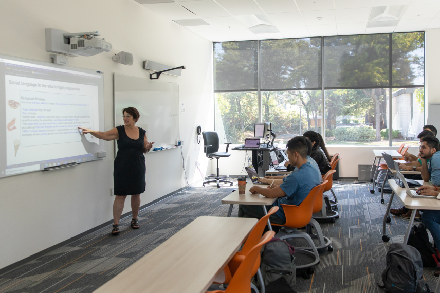 Instructor teaching in SVC classroom with students listening to lecture