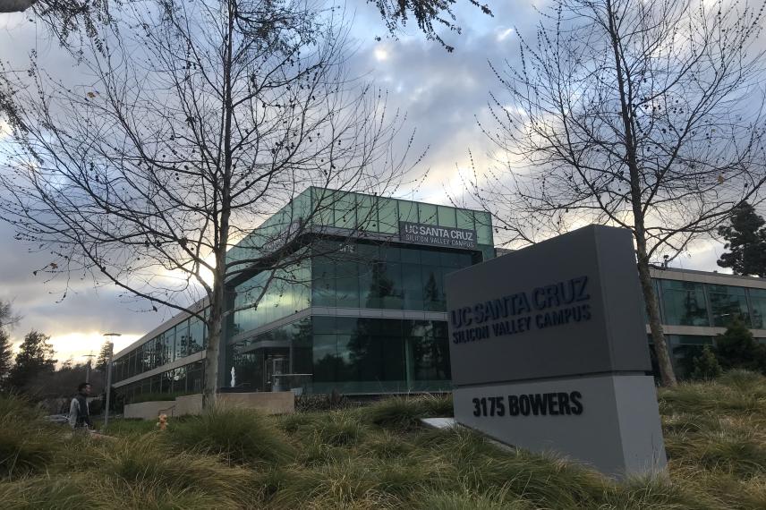 side view of name sign and UNEX campus building