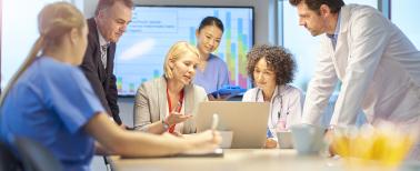 Medical and business professionals in a conference room reviewing data