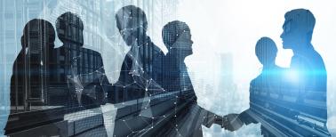 Silhouette of business people shaking hands in city office building background.