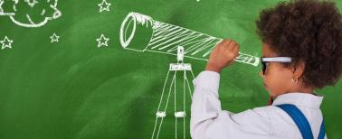 Preschool child looking through telescope