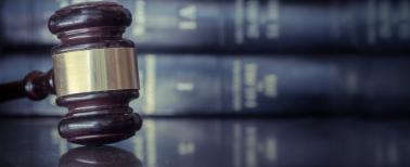Judicial gavel on table with a background of law books
