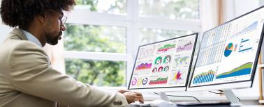 Business man at a desk looking at charts and data graphs on 