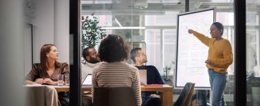 Project Manager Makes a Presentation for a Young Diverse Creative Team in Meeting Room in an Agency.