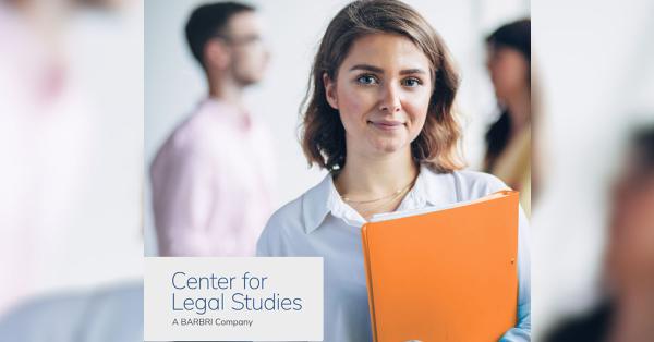 young woman holding notebook with people blurred in the background.