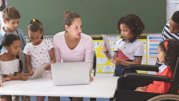 Women sitting next to child in classroom.